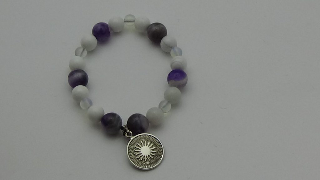 PULSERA DE CUARZO AMATISTA, CUARZO PIEDRA LUNA Y CUARZO HOWLITA BLANCA CON DIJE DEL ENEGRAMA SOLAR DE PLATA