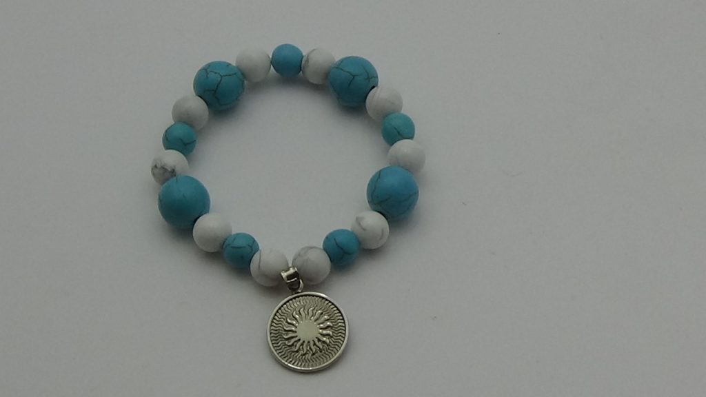 PULSERA DE CUARZO TURQUESA Y CUARZO HOWLITA BLANCA CON DIJE DEL ENEGRAMA SOLAR DE PLATA
