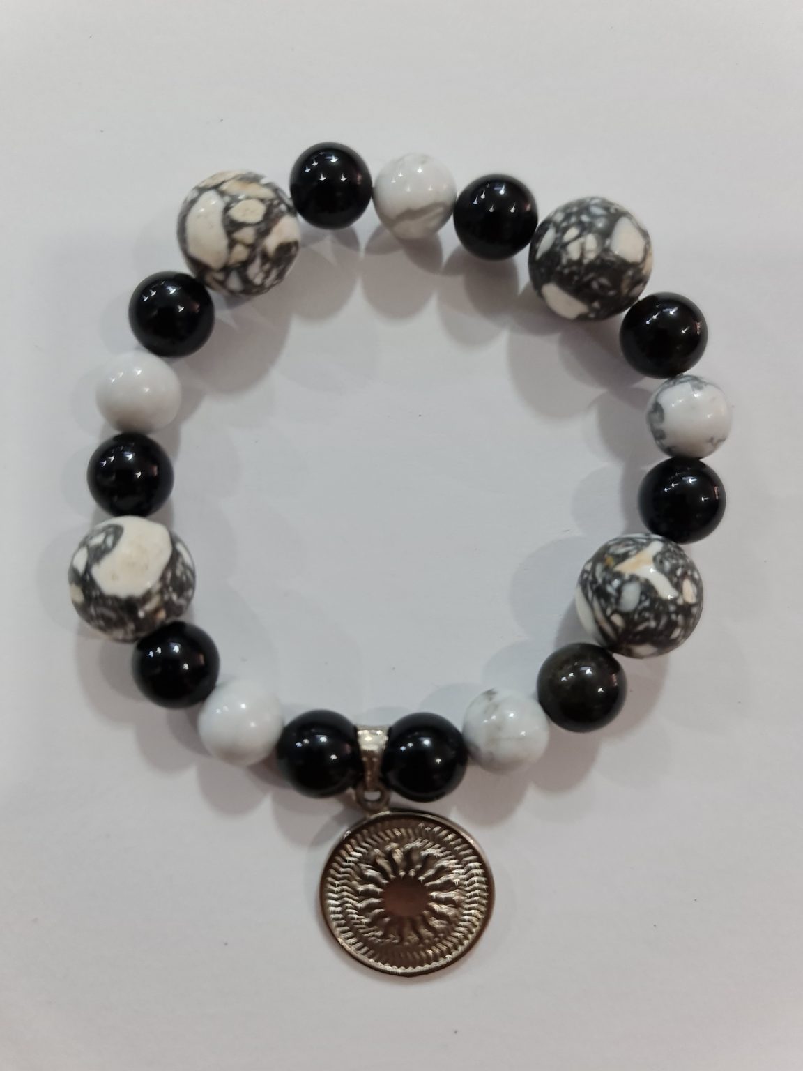PULSERA DE CUARZO HOWLITA BLANCA Y CUARZO OBSIDIANA CON DIJE DEL ENEGRAMA SOLAR DE PLATA