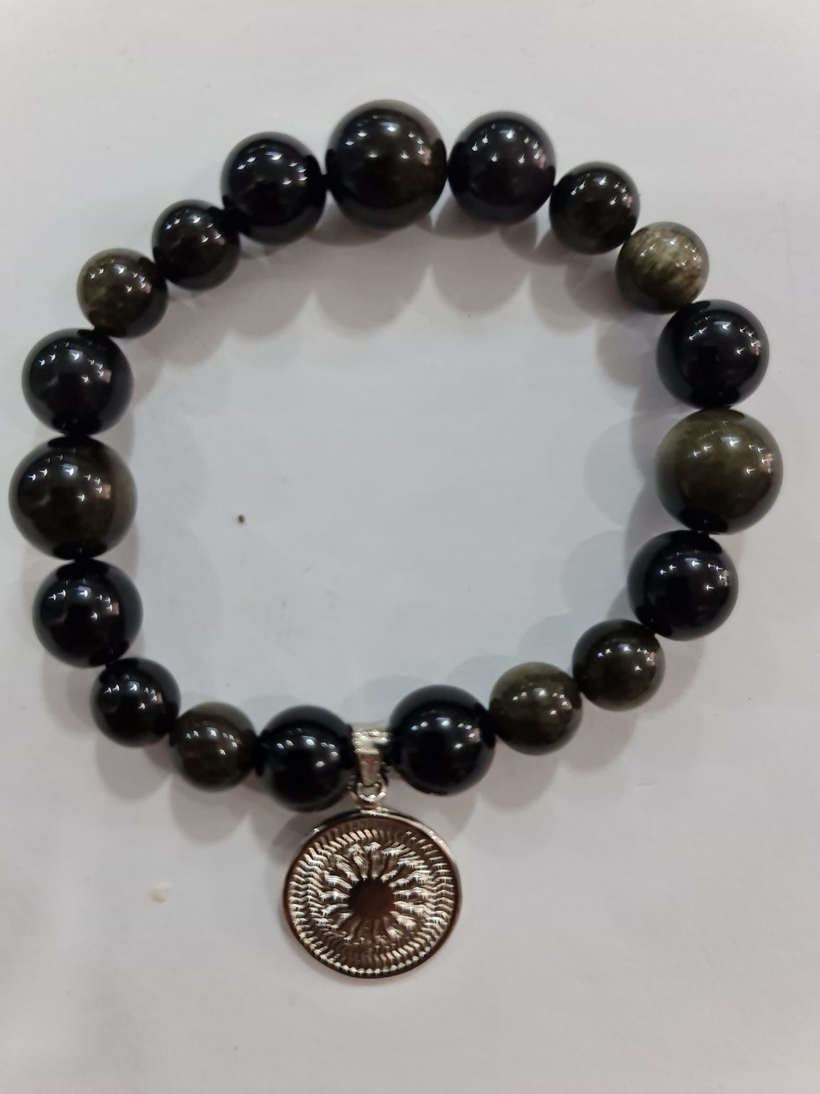 PULSERA DE CUARZO OBSIDIANA ARCOÍRIS CON DIJE DEL ENEGRAMA SOLAR DE PLATA