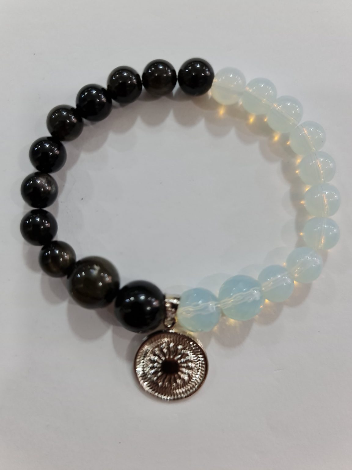 PULSERA DE CUARZO PIDRA LUNA Y CUARZO OBSIDIANA CON DIJE DEL ENEGRAMA SOLAR DE PLATA