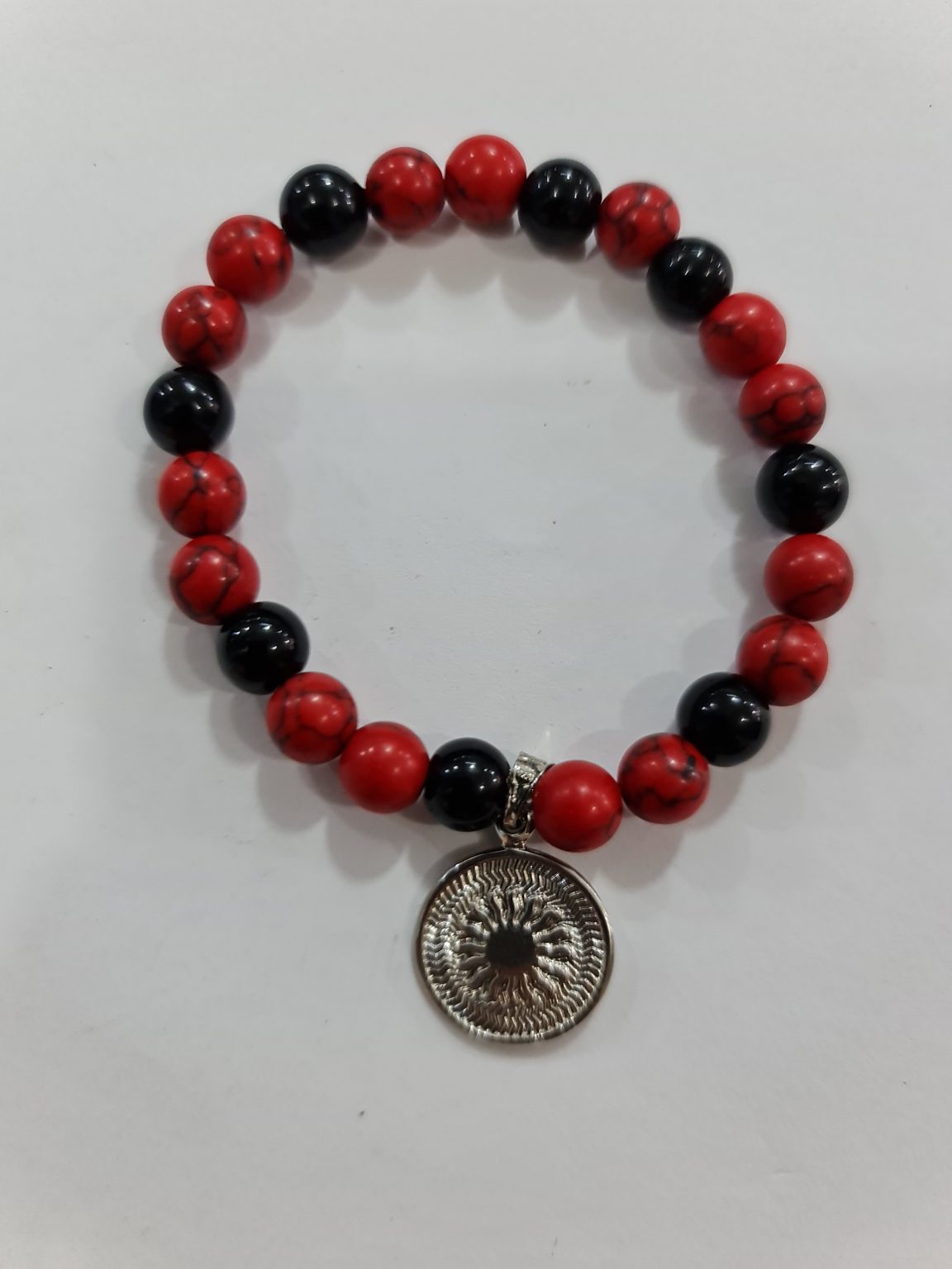 PULSERA DE CUARZO HOWLITA ROJA Y CUARZO OBSIDIANA CON DIJE DEL ENEGRAMA SOLAR DE PLATA