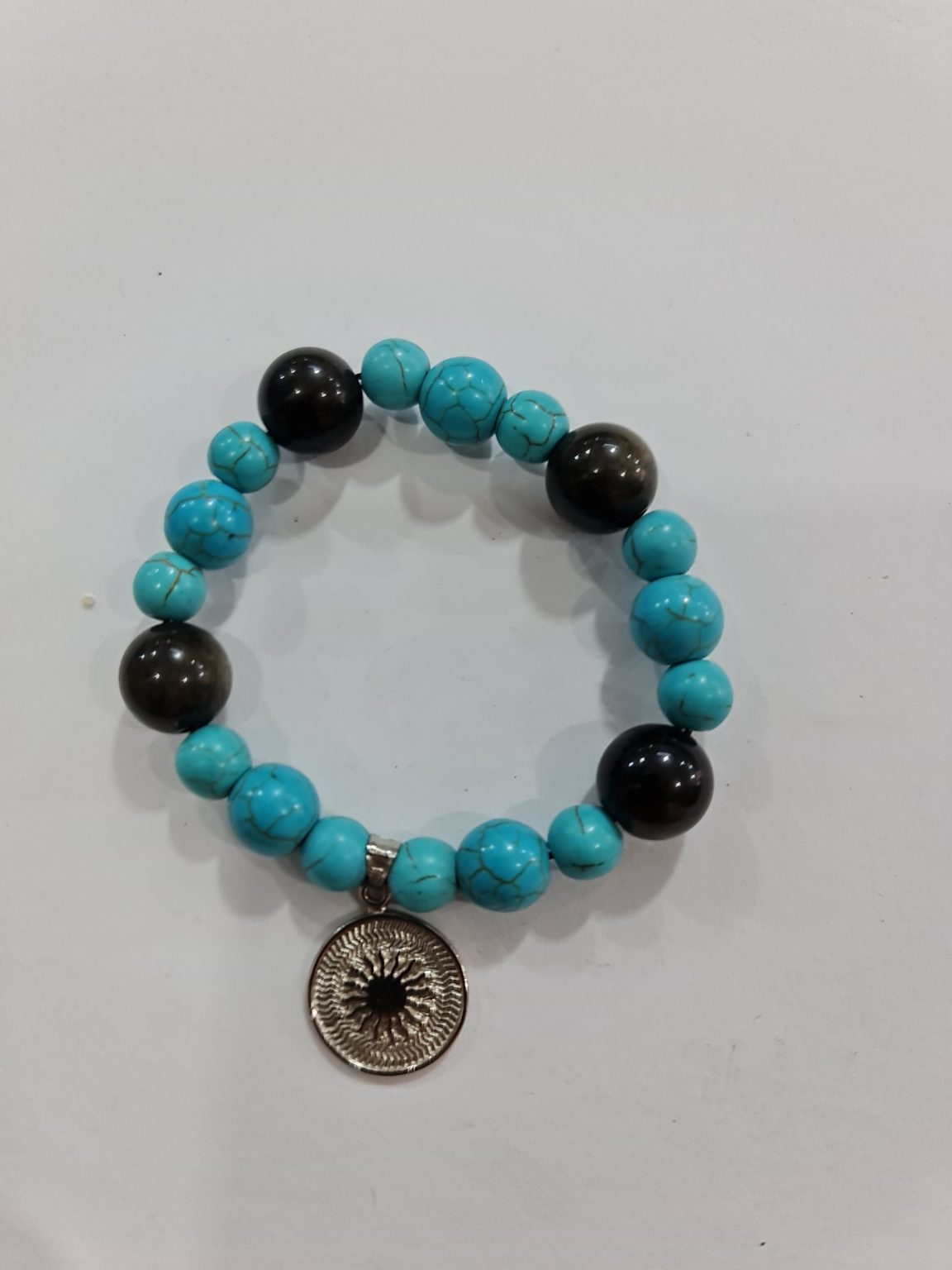 PULSERA DE CUARZO TURQUESA Y CUARZO OBSIDIANA CON DIJE DEL ENEGRAMA SOLAR DE PLATA