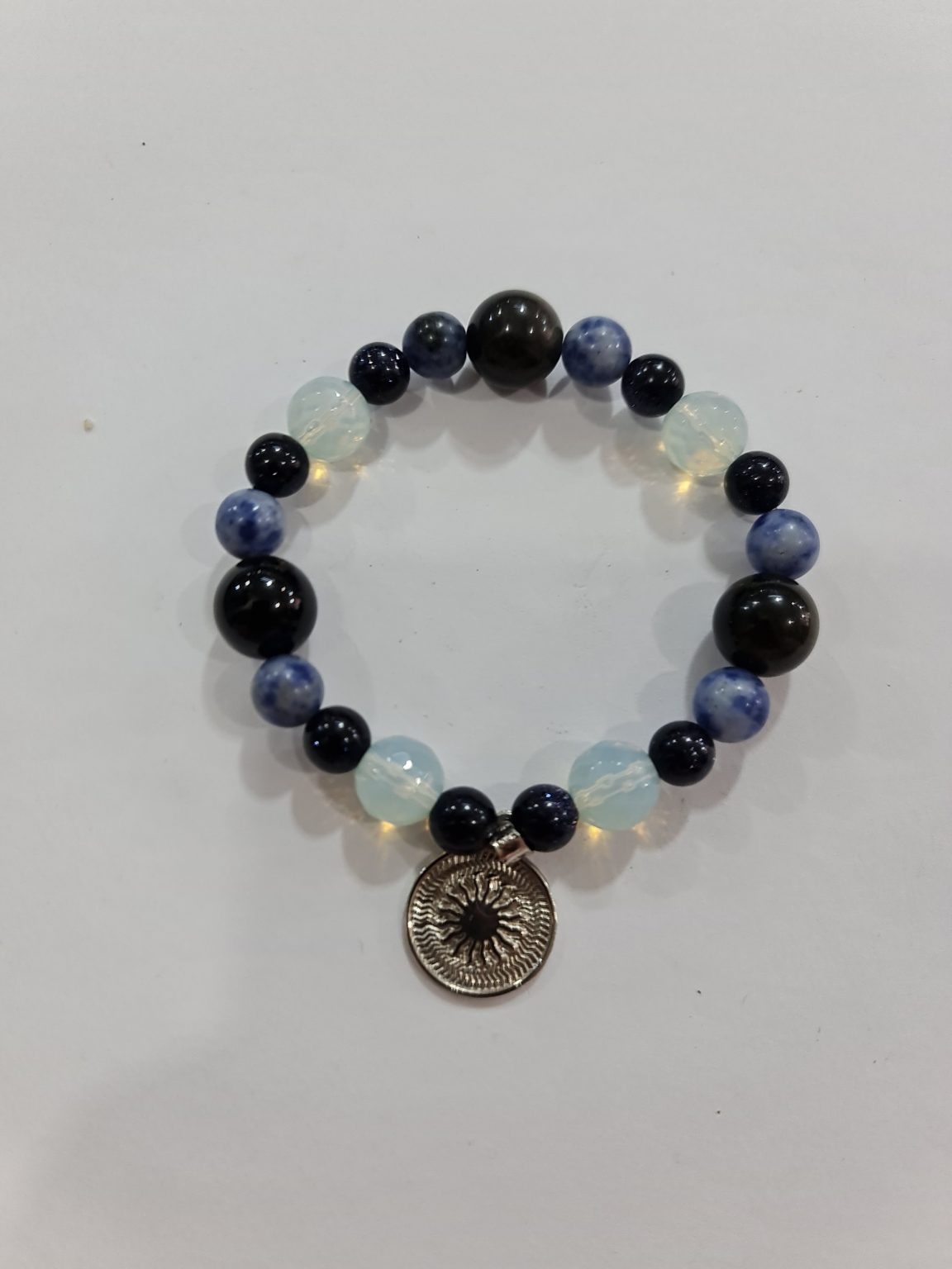 PULSERA DE CUARZO PIEDRA LUNA, CUARZO OBSIDIANA Y CUARZO SODALITA CON DIJE DEL ENEGRAMA SOLAR DE PLATA