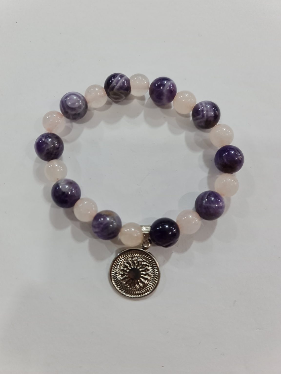 PULSERA DE CUARZO AMATISTA Y CUARZO ROSA CON DIJE DEL ENEGRAMA SOLAR DE PLATA