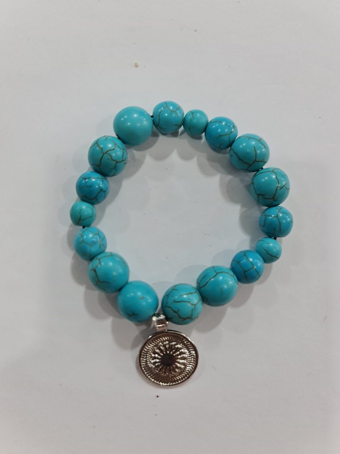 PULSERA DE CUARZO TURQUESA CON DIJE DEL ENEGRAMA SOLAR DE PLATA