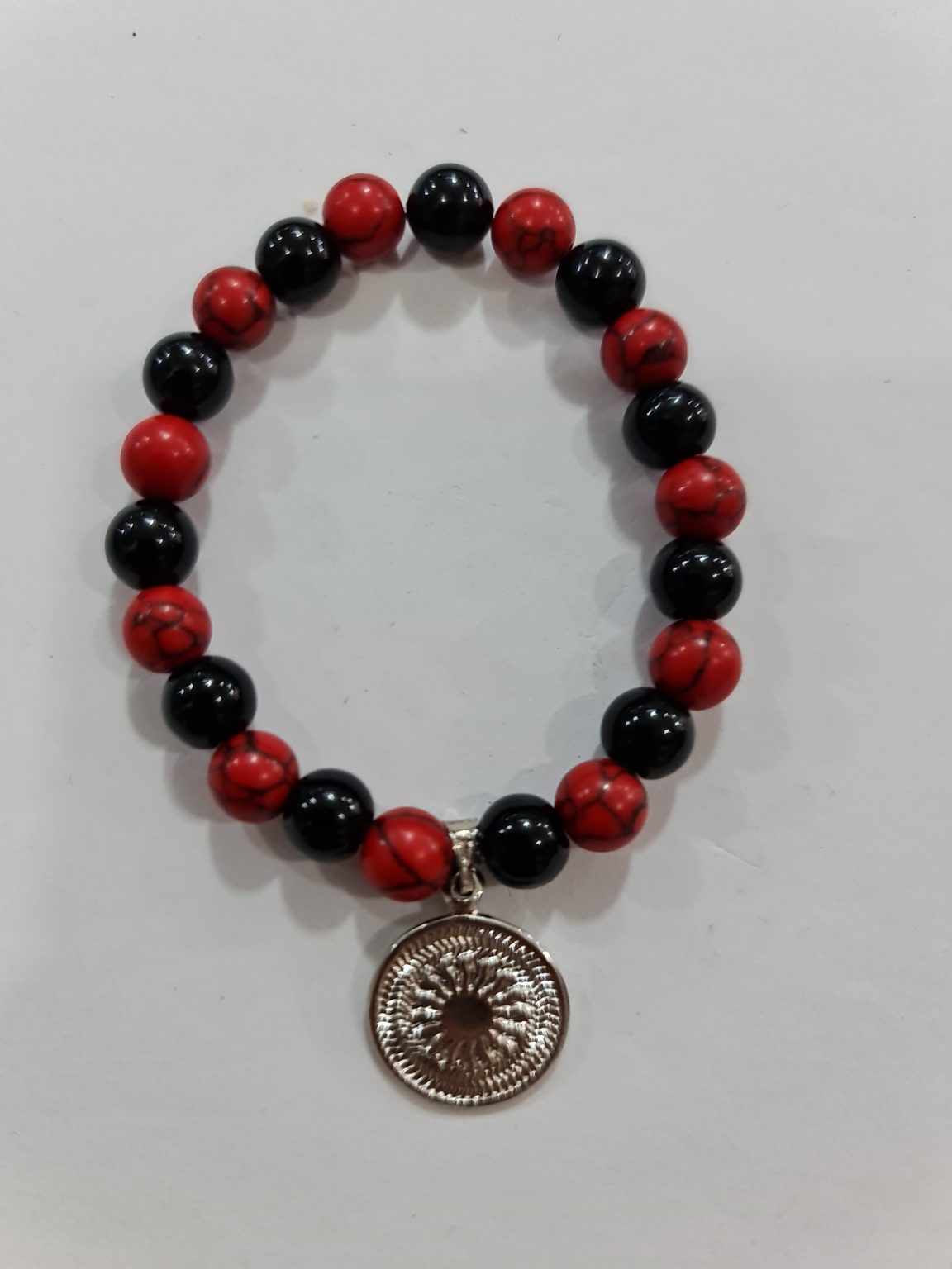 PULSERA DE CUARZO OBSIDIANA Y CUARZO HOWLITA ROJA CON DIJE DEL ENEGRAMA SOLAR DE PLATA