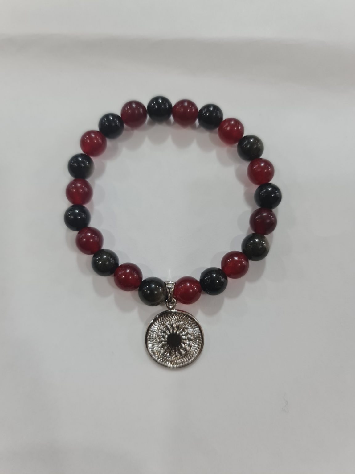 PULSERA DE CUARZO OBSIDIANA Y CUARZO ROJO CON DIJE DEL ENEGRAMA SOLAR DE PLATA