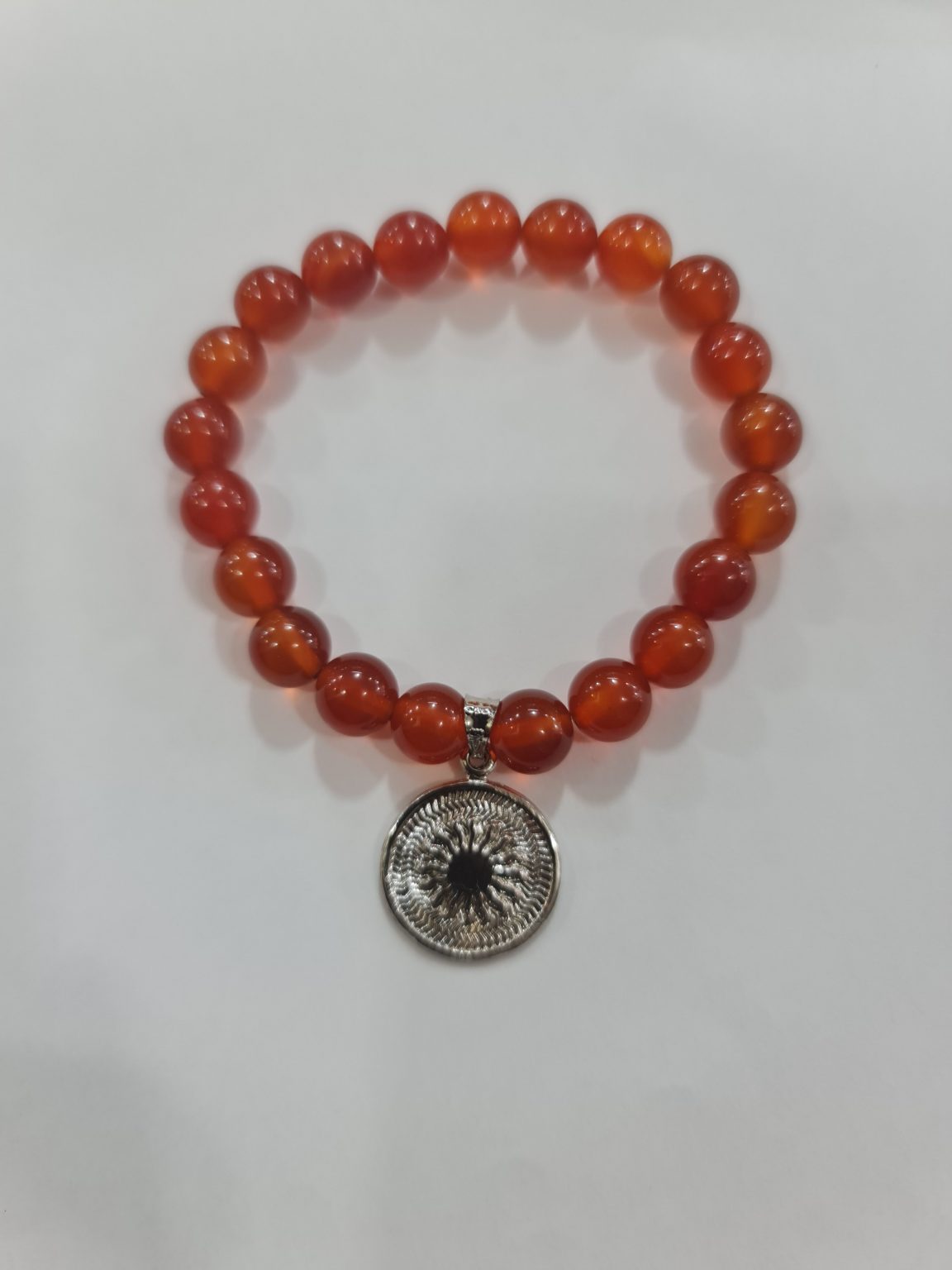 PULSERA DE CUARZO CORNALINA CON DIJE DEL ENEGRAMA SOLAR DE PLATA